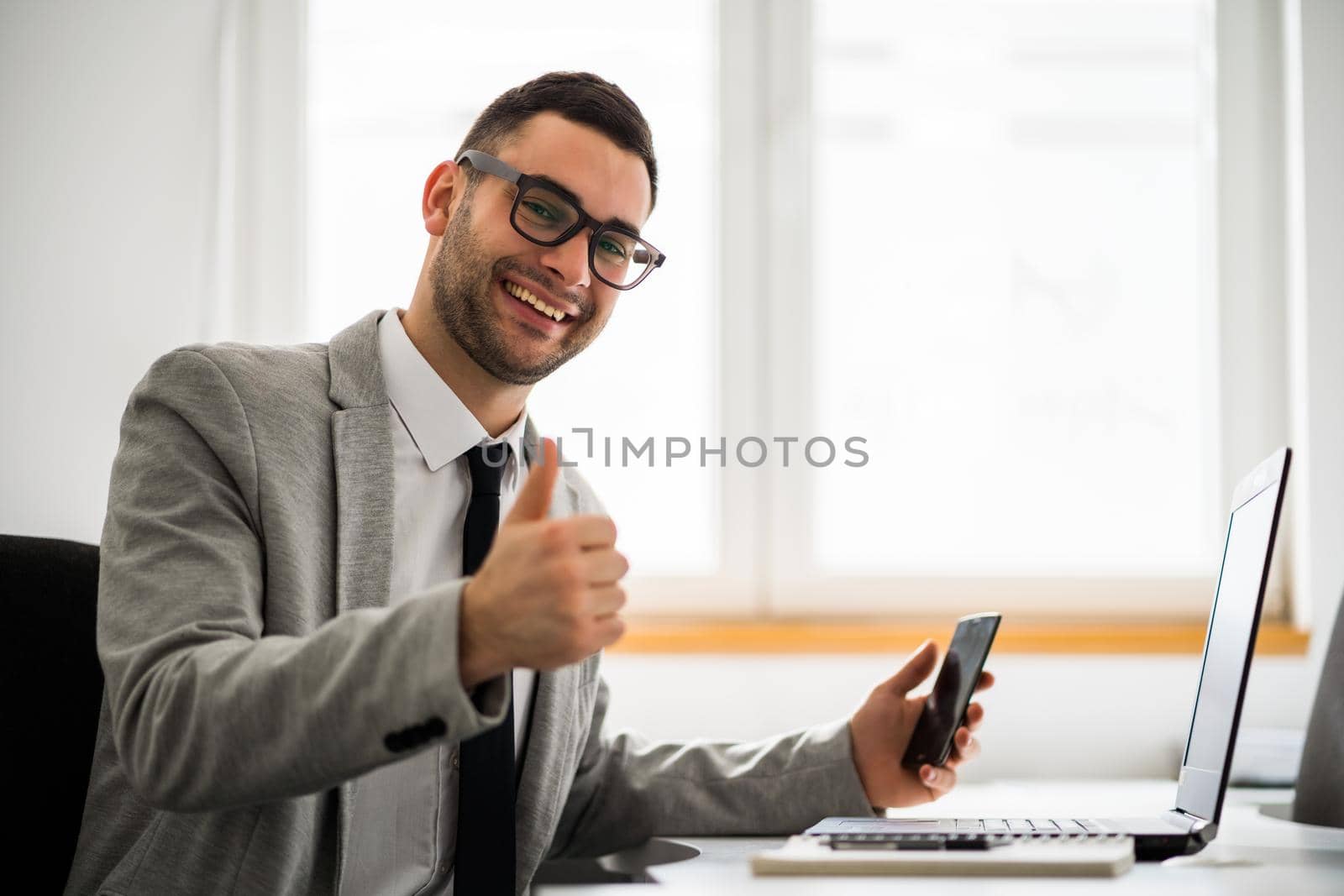 Young happy businessman is working in office.