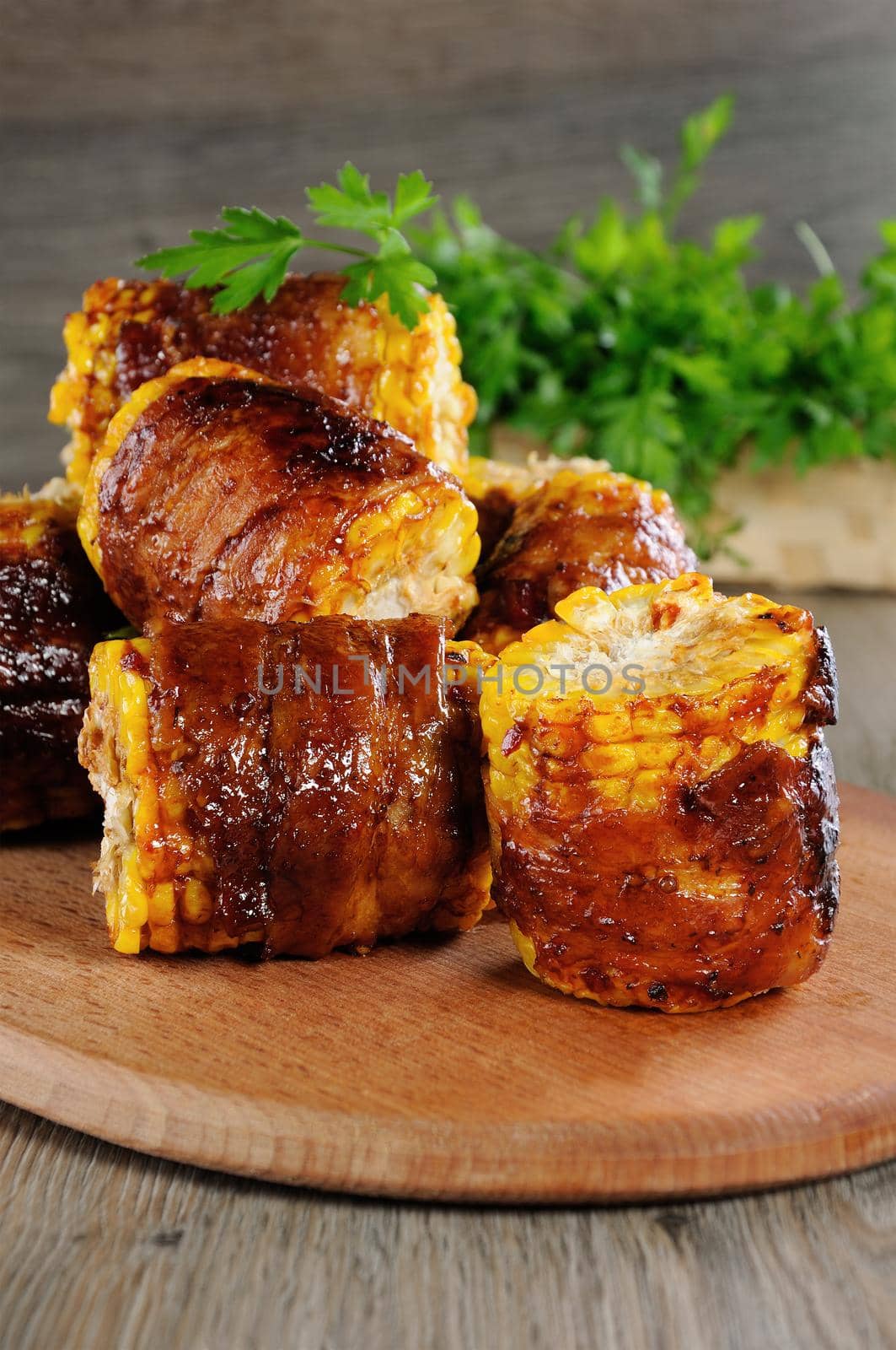 Grilled corn wrapped with bacon slices under BBQ sauce