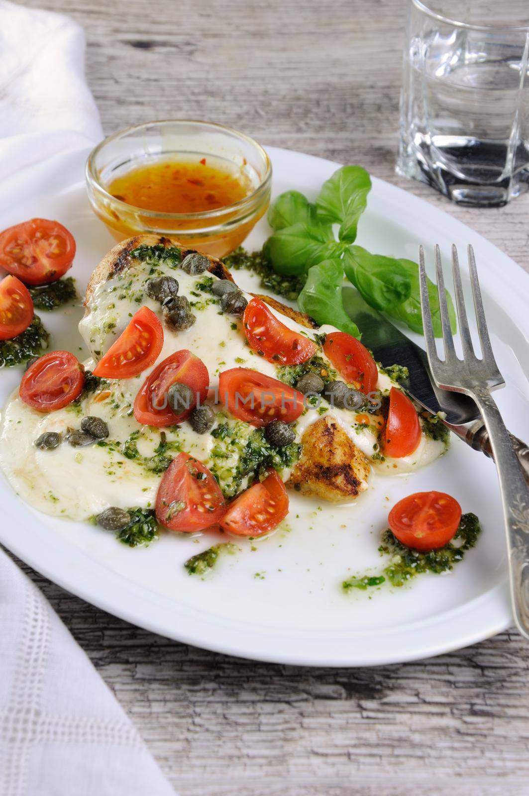 grilled chicken breast  topped with melted mozzarella cheese, basil  pesto, tomato  and caper
