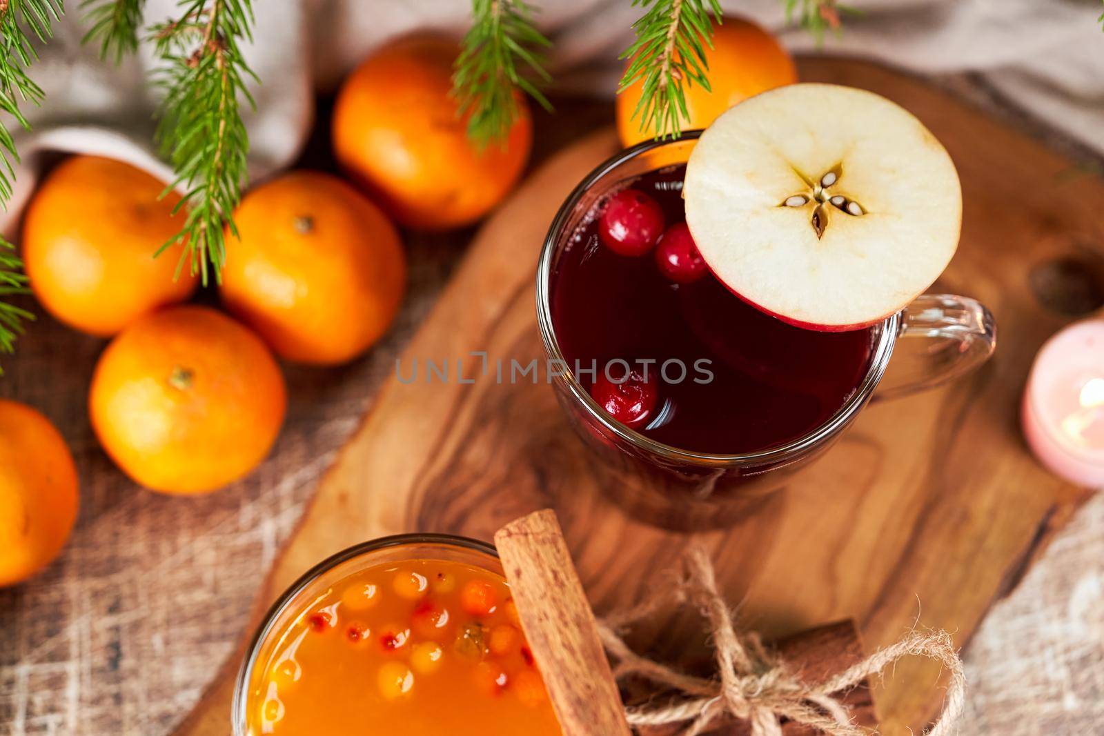 Red and yellow mulled wine in glass mugs on a Christmas table with tangerines. New Year's still life, top view