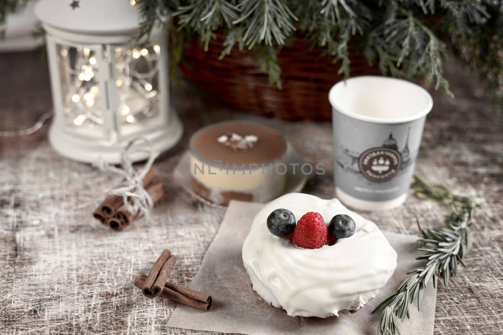 A cake decorated with blackberries and raspberries on a New Year table with a flashlight and a spruce branch. Frame toning