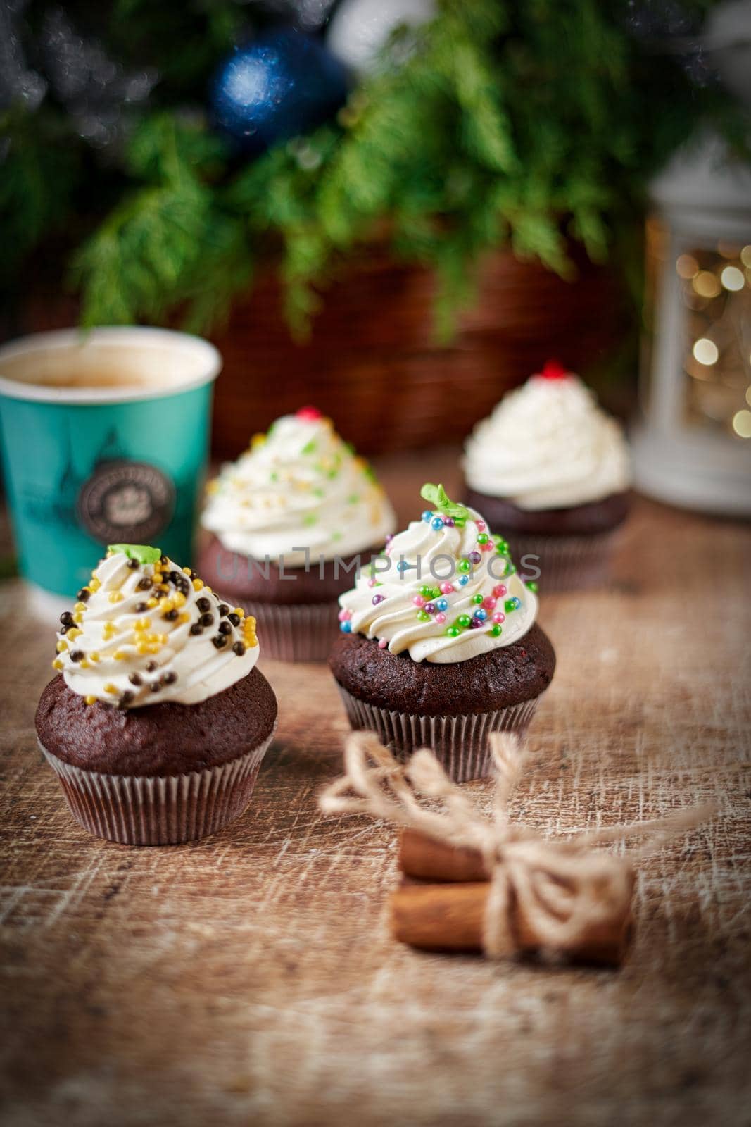 Chocolate muffins cake and coffee on a New Year's table with a flashlight and a spruce branch. New Yea still life