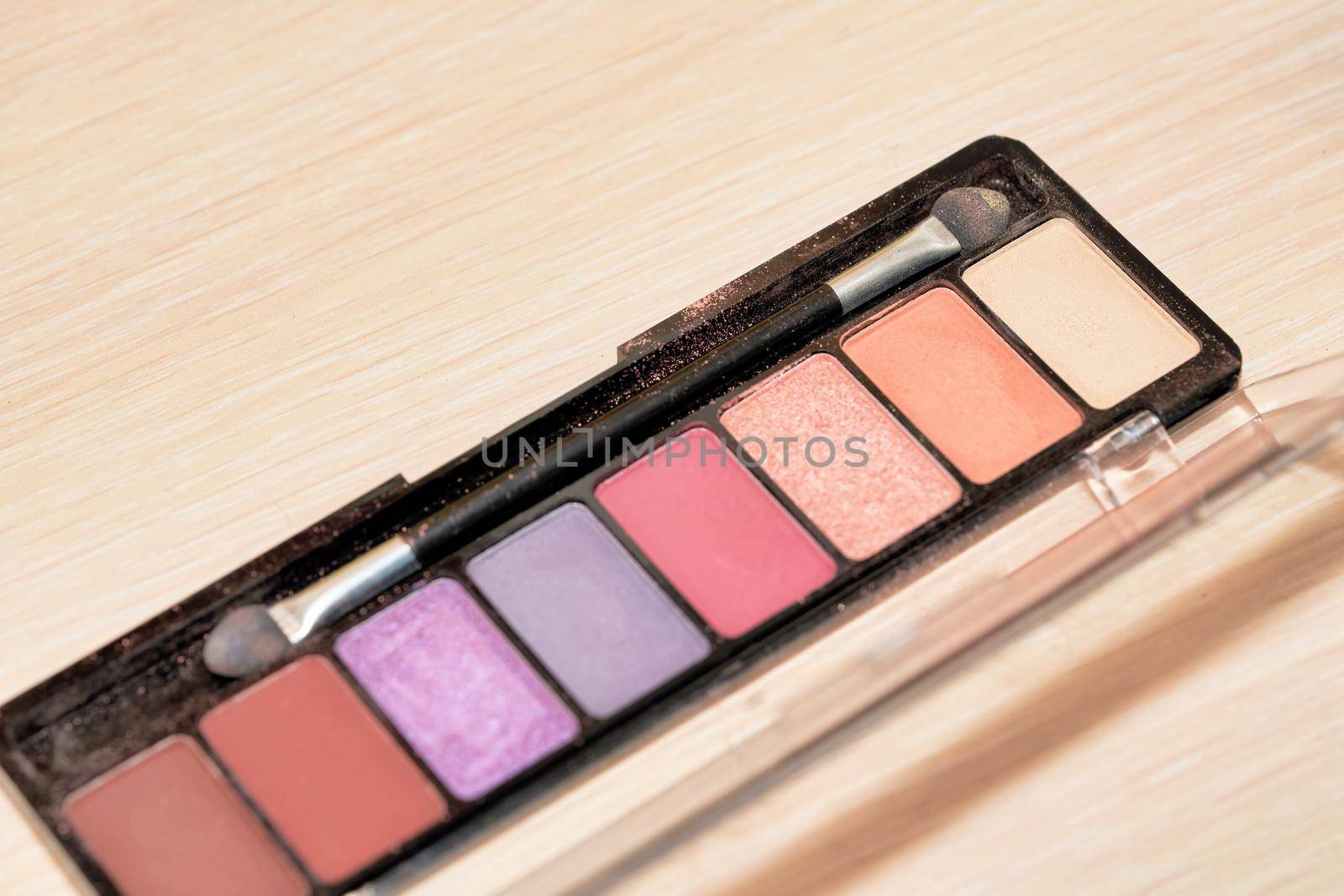 Open Box of Multicolored Eyeshadow with Makeup Brush