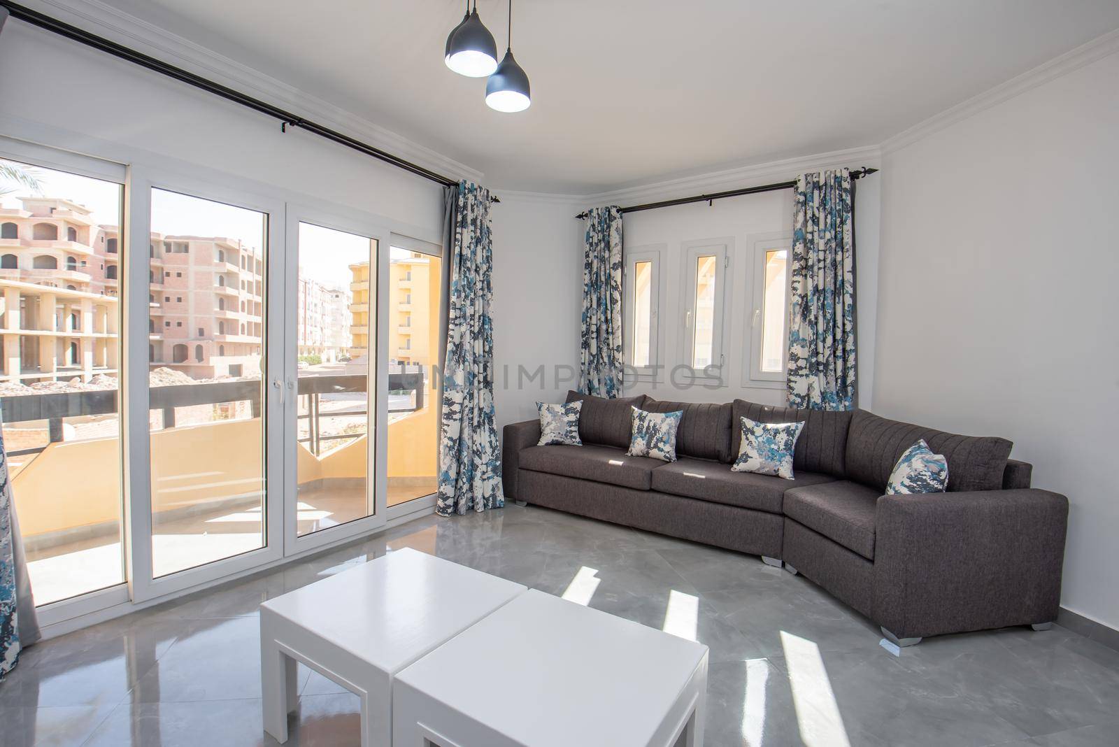 Living room lounge area in luxury apartment show home showing interior design decor furnishing with balcony