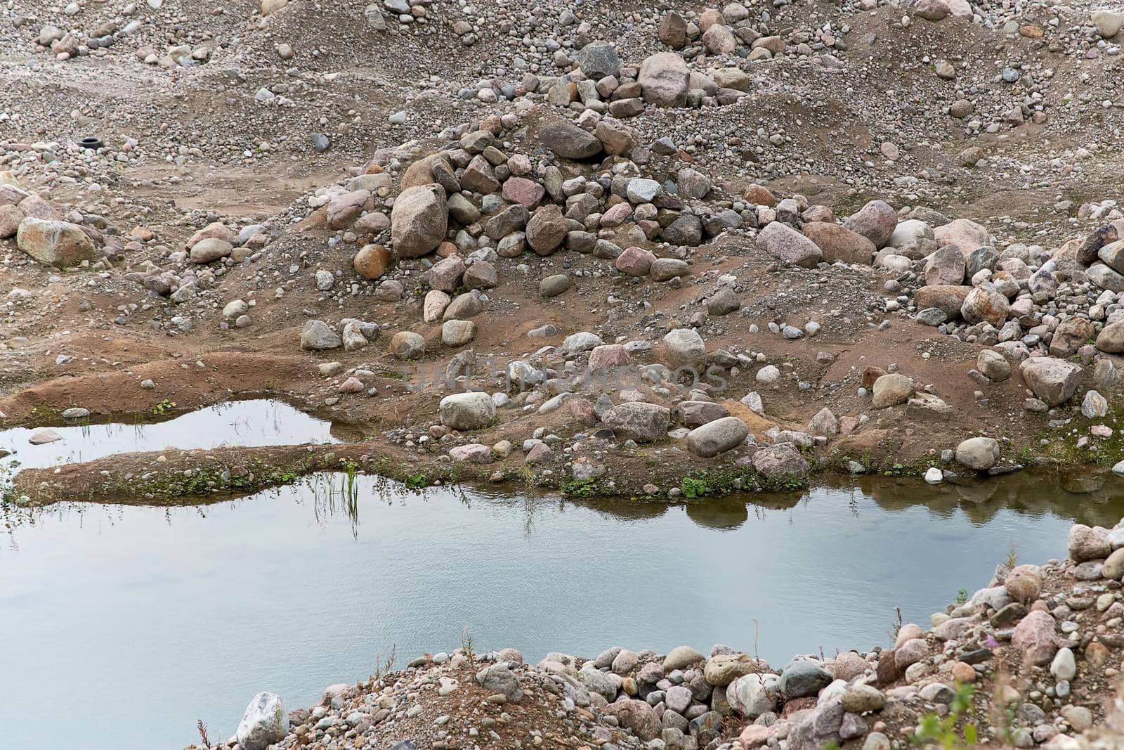 Fragment of a quarry with sand and stones filling with water by vizland