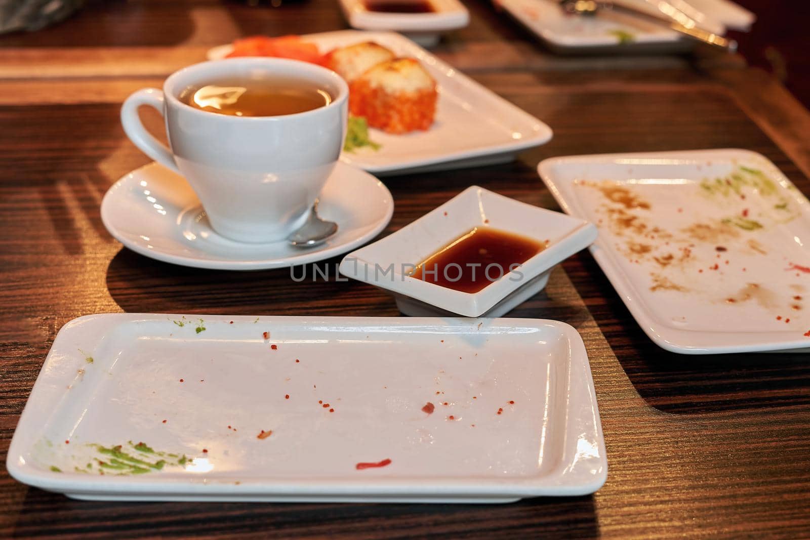 Fragment of a table in a restaurant with uncleaned dishes after a meal by vizland