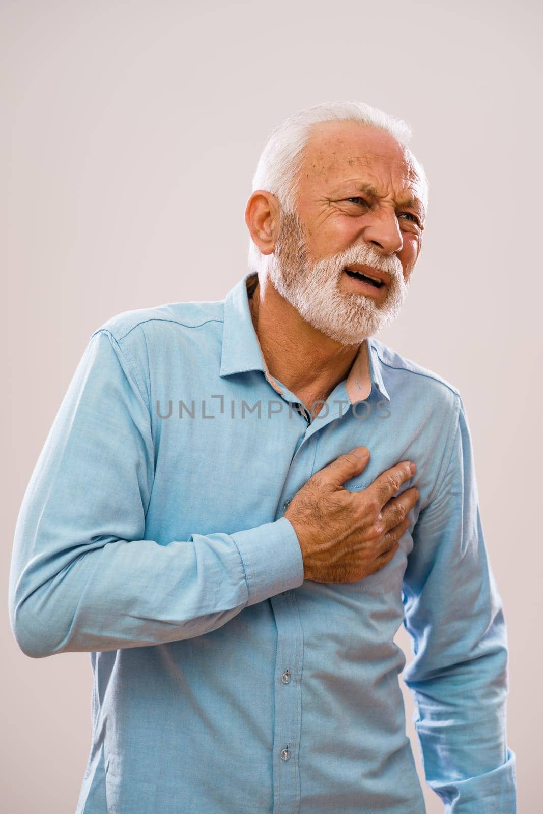 Portrait of senior man who is having pain in his chest.