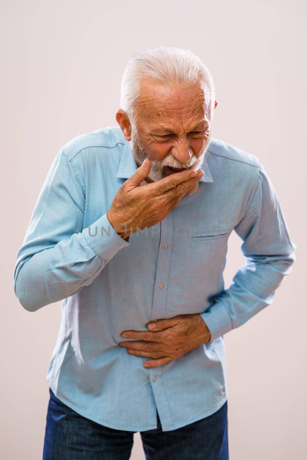 Portrait of senior man who is having pain in stomach.