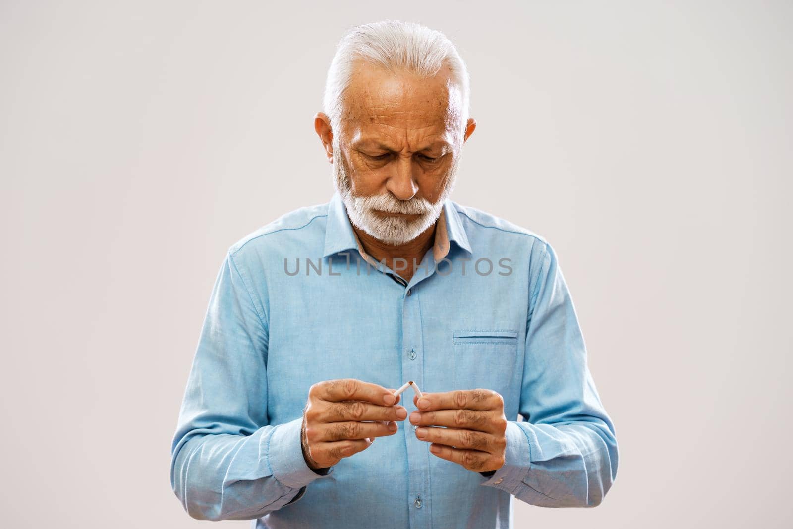 Portrait of serious senior man who is decided to quit smoking.