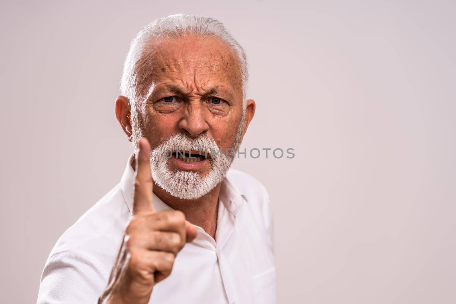 Portrait of angry senior man who threatens.