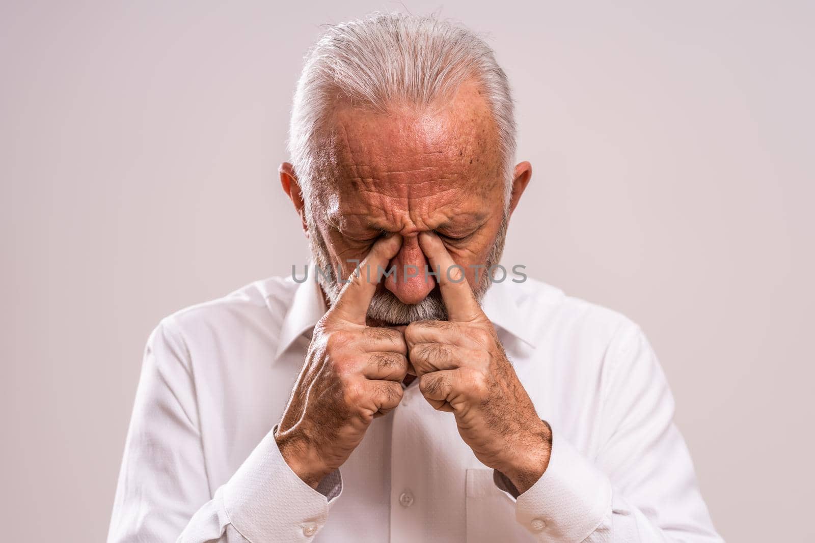 Portrait of senior man who is having pain in sinus.