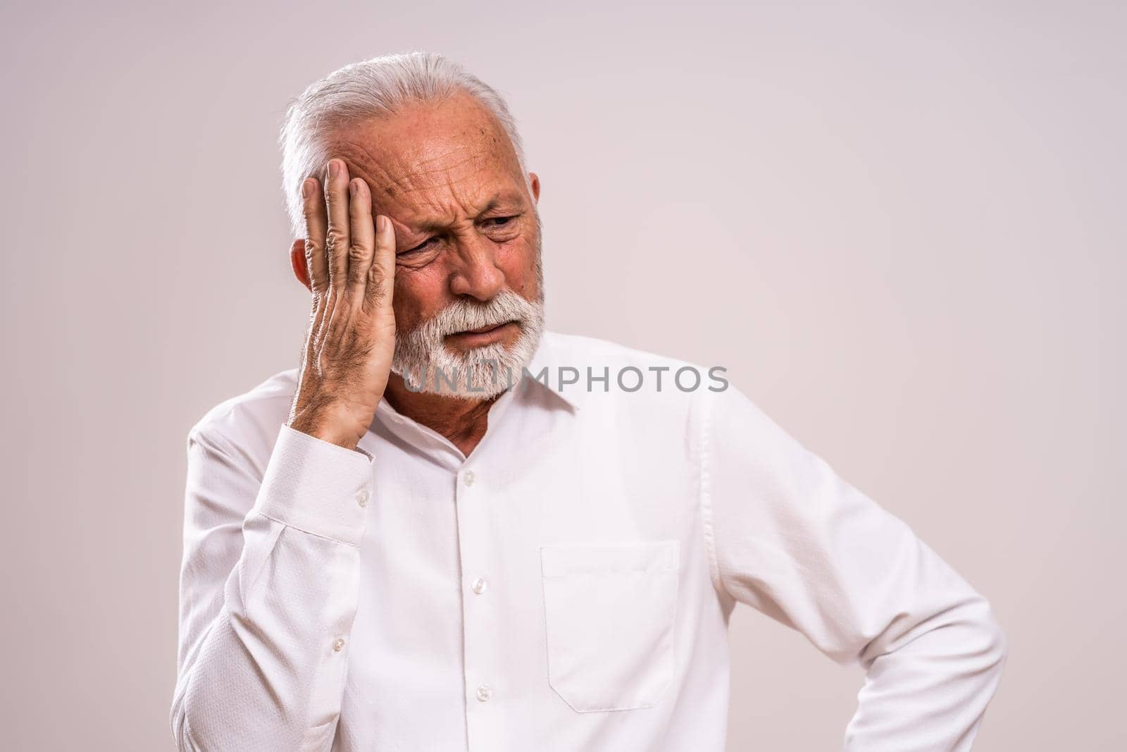 Portrait of senior man who is having headache.