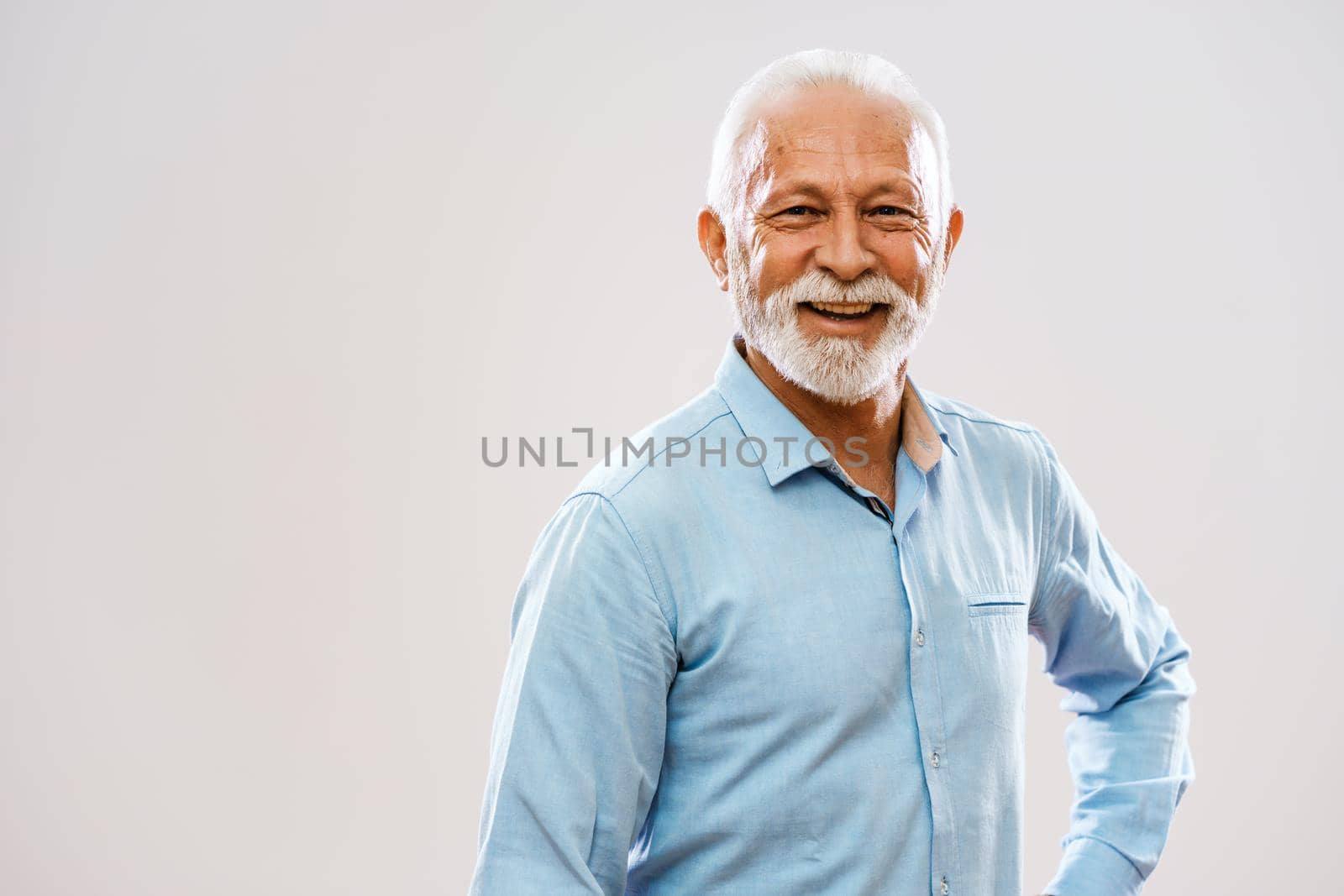 Studio shot portrait of cheerful senior man.