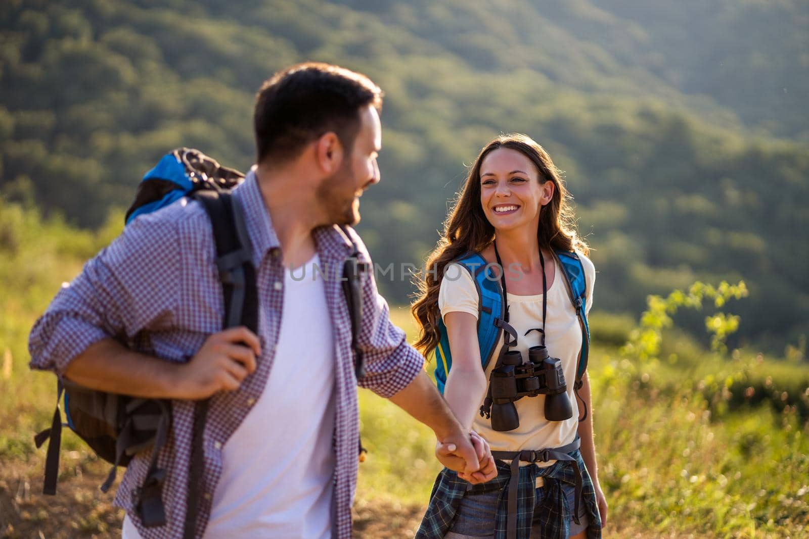 Happy couple is hiking in mountain in summertime.