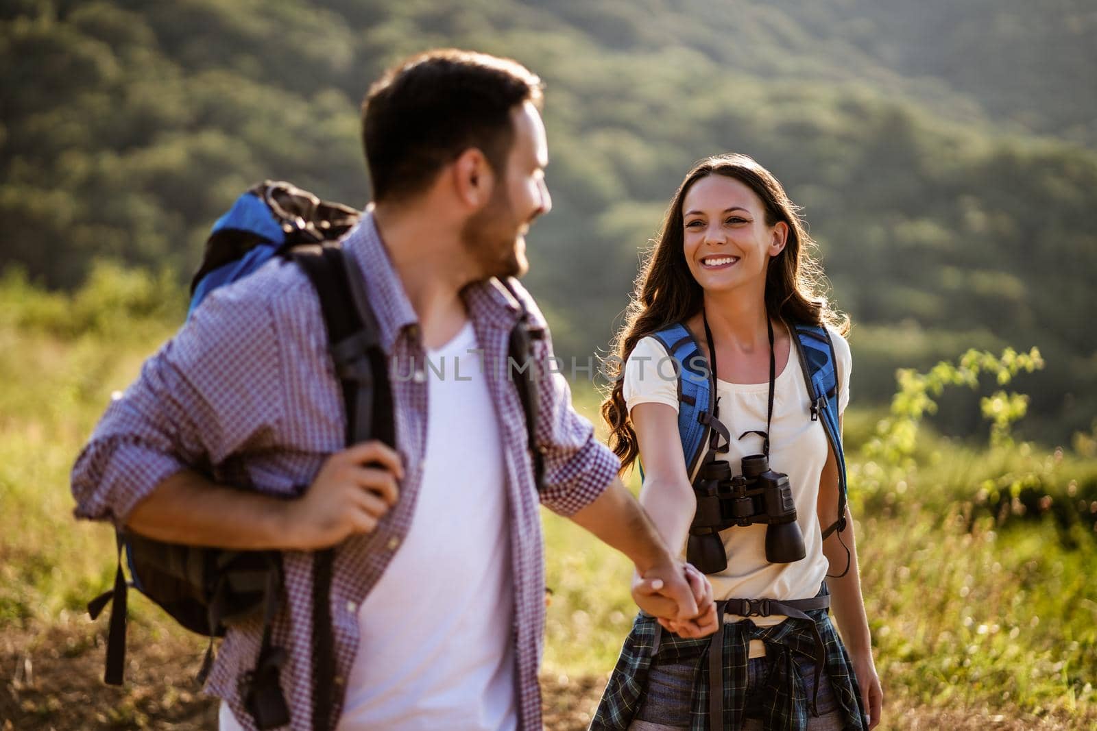 Happy couple is hiking in mountain in summertime.