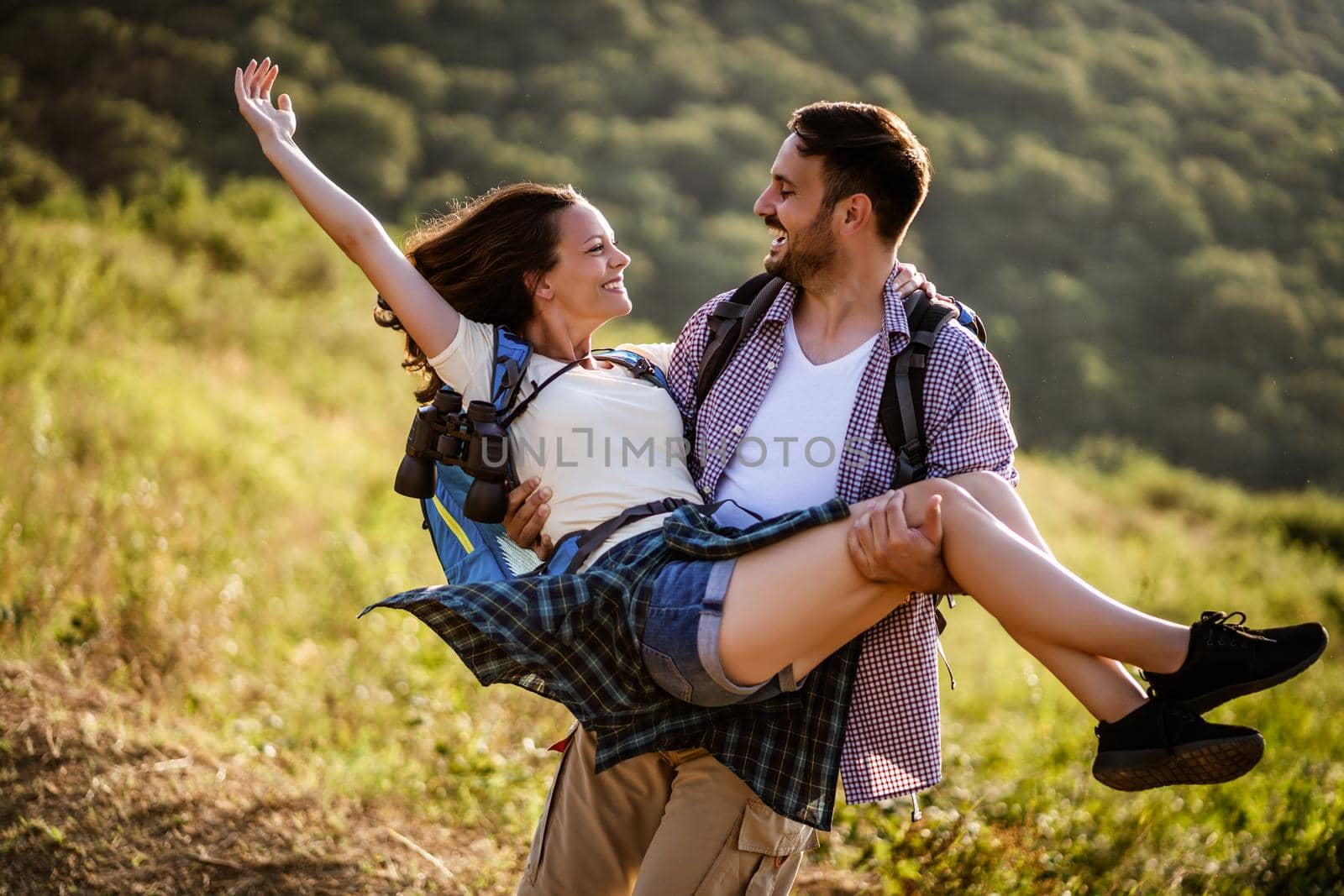 Happy couple is having fun while hiking in mountain.