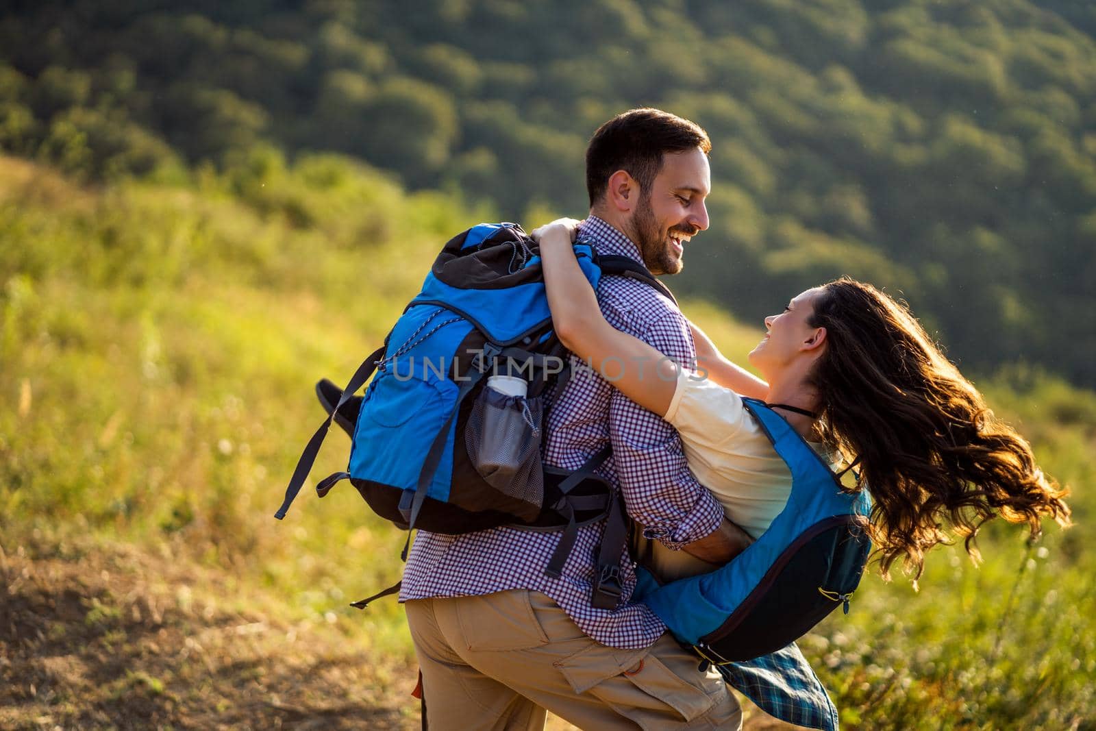 Happy couple is having fun while hiking in mountain.