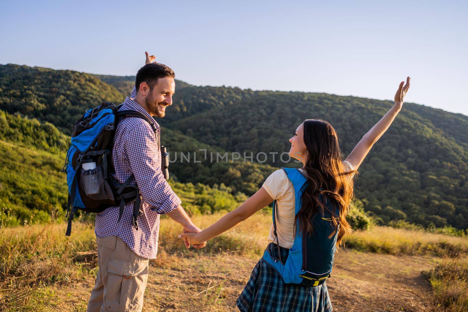 Happy couple is ready for hiking in mountain.