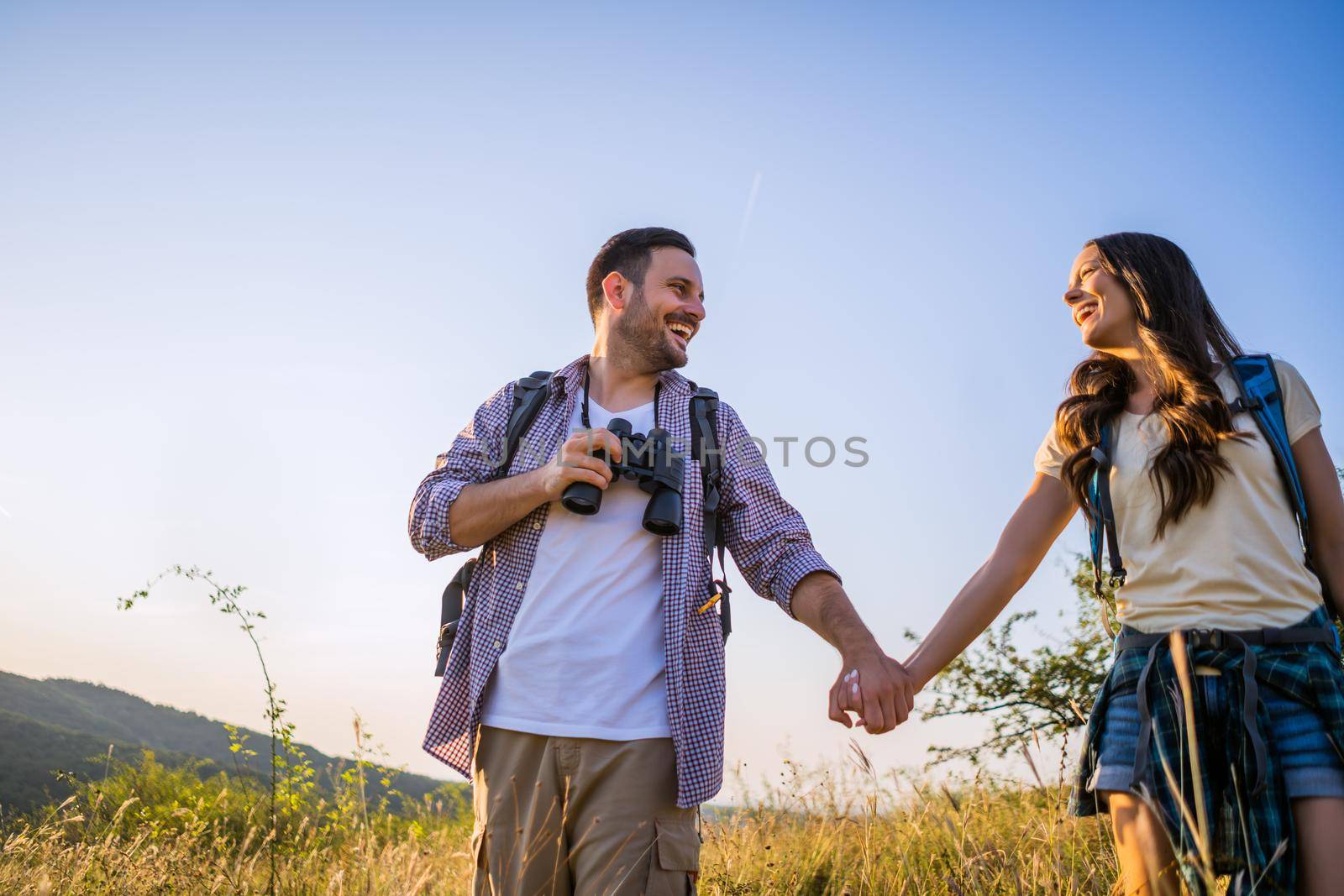 Happy couple is hiking in mountain.