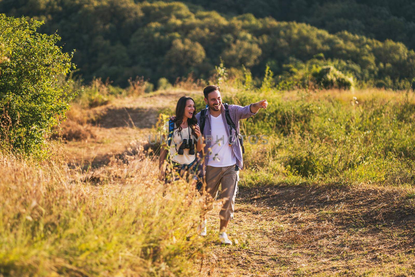 Happy couple is hiking in mountain.