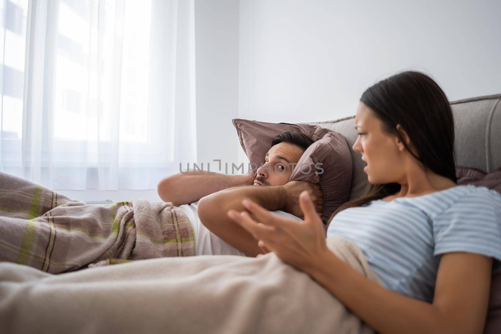 Young couple is arguing in bed.