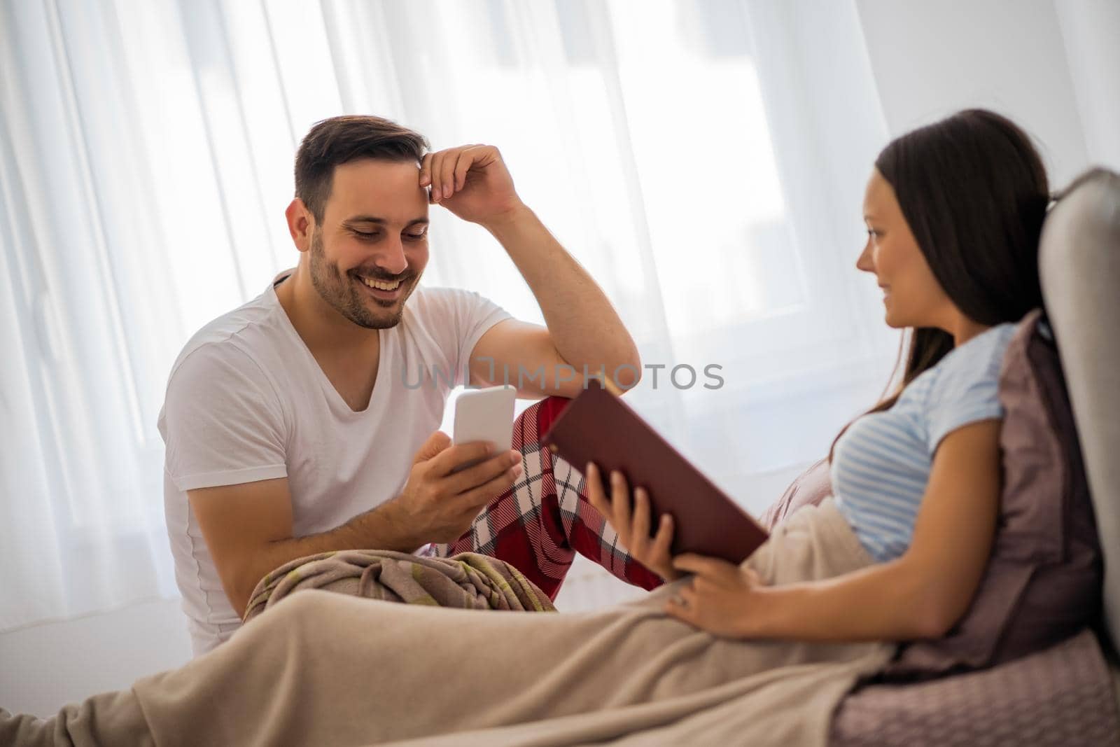 Young happy couple in bed in the morning.