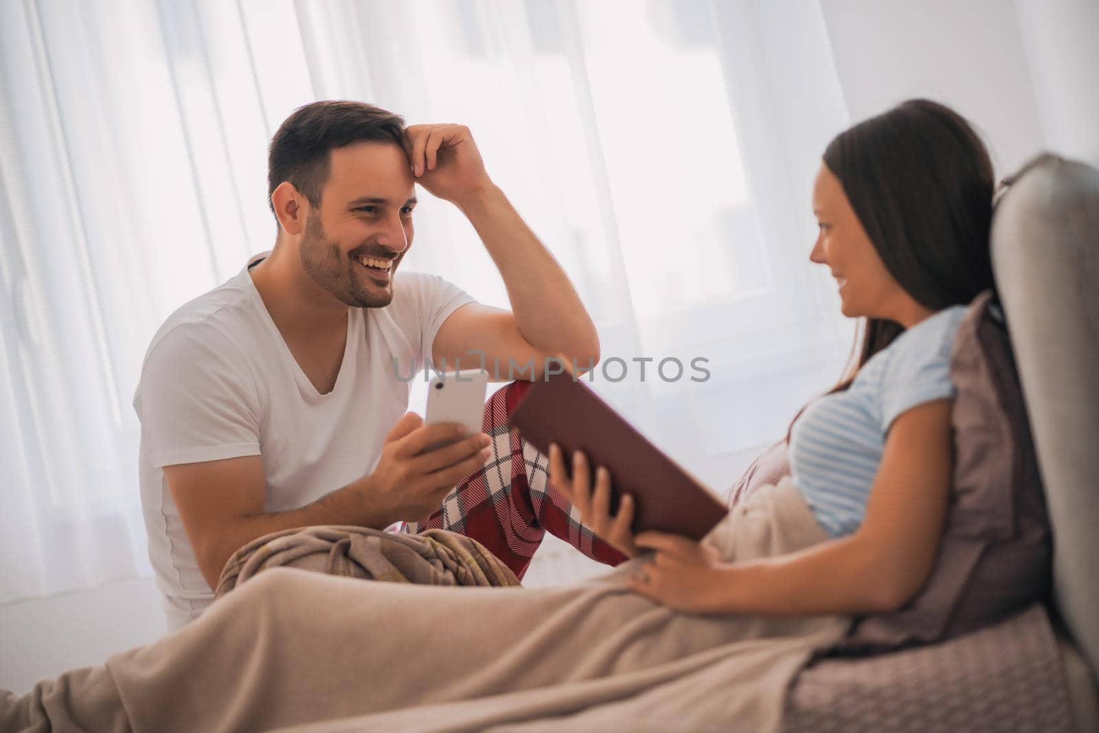 Young happy couple in bed in the morning.