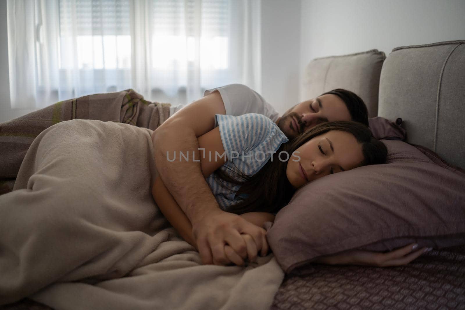 Young couple is sleeping in their bed.