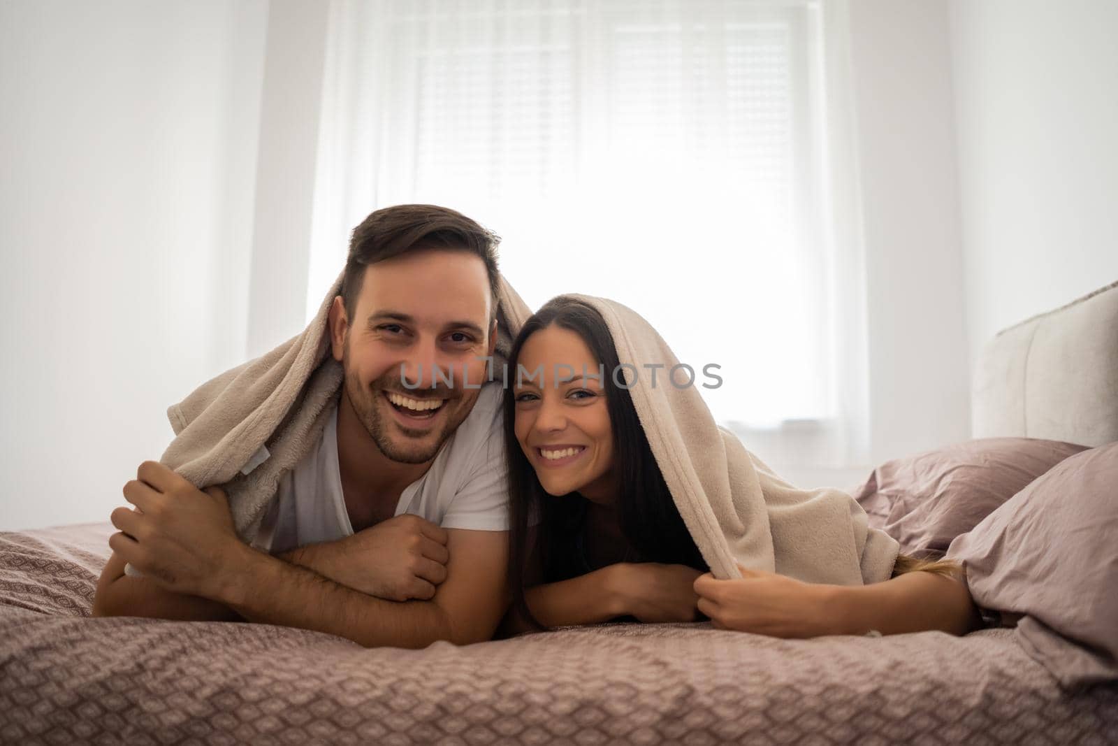Happy couple is having fun in bed.