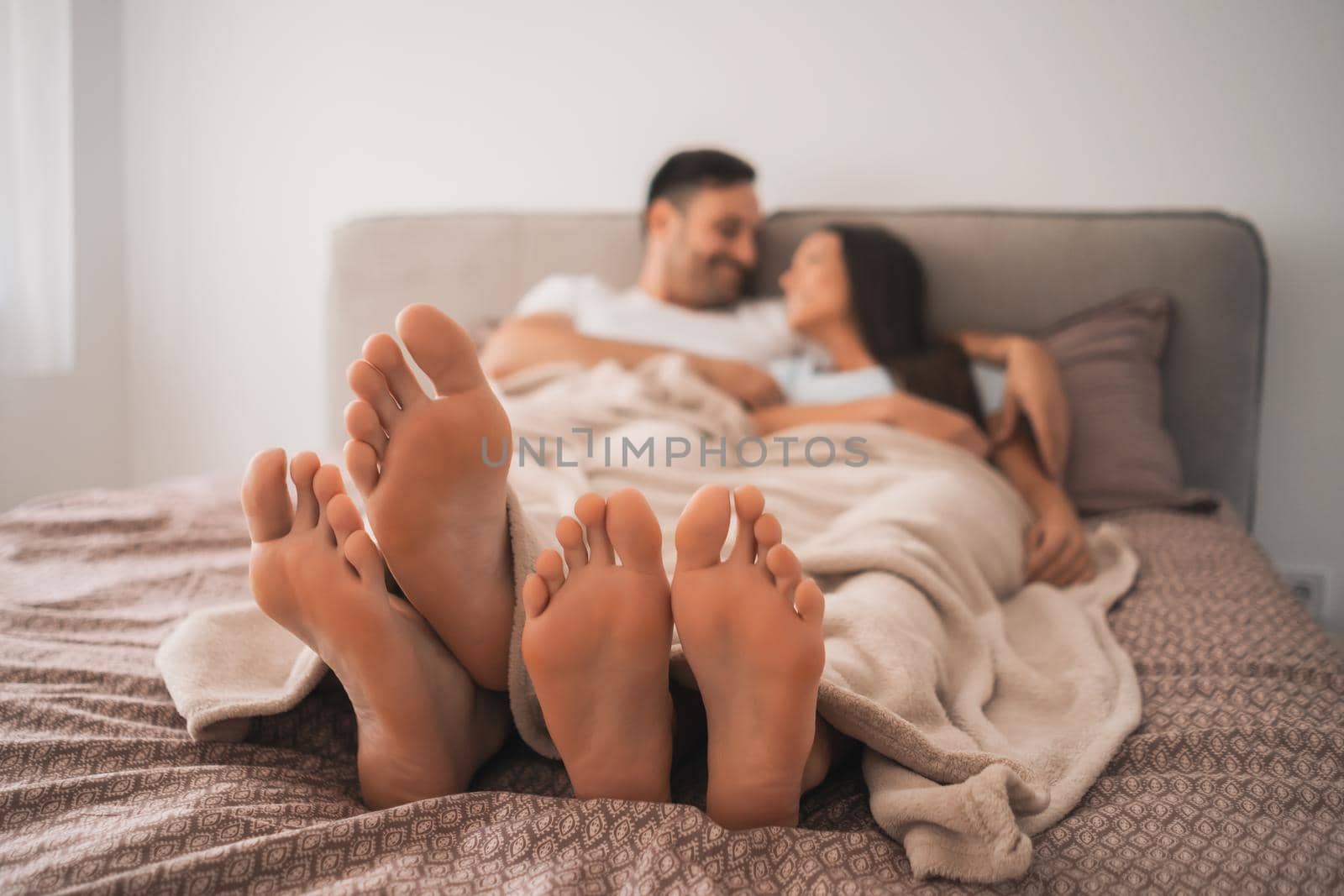 Happy couple is enjoying and relaxing themselves in bed.