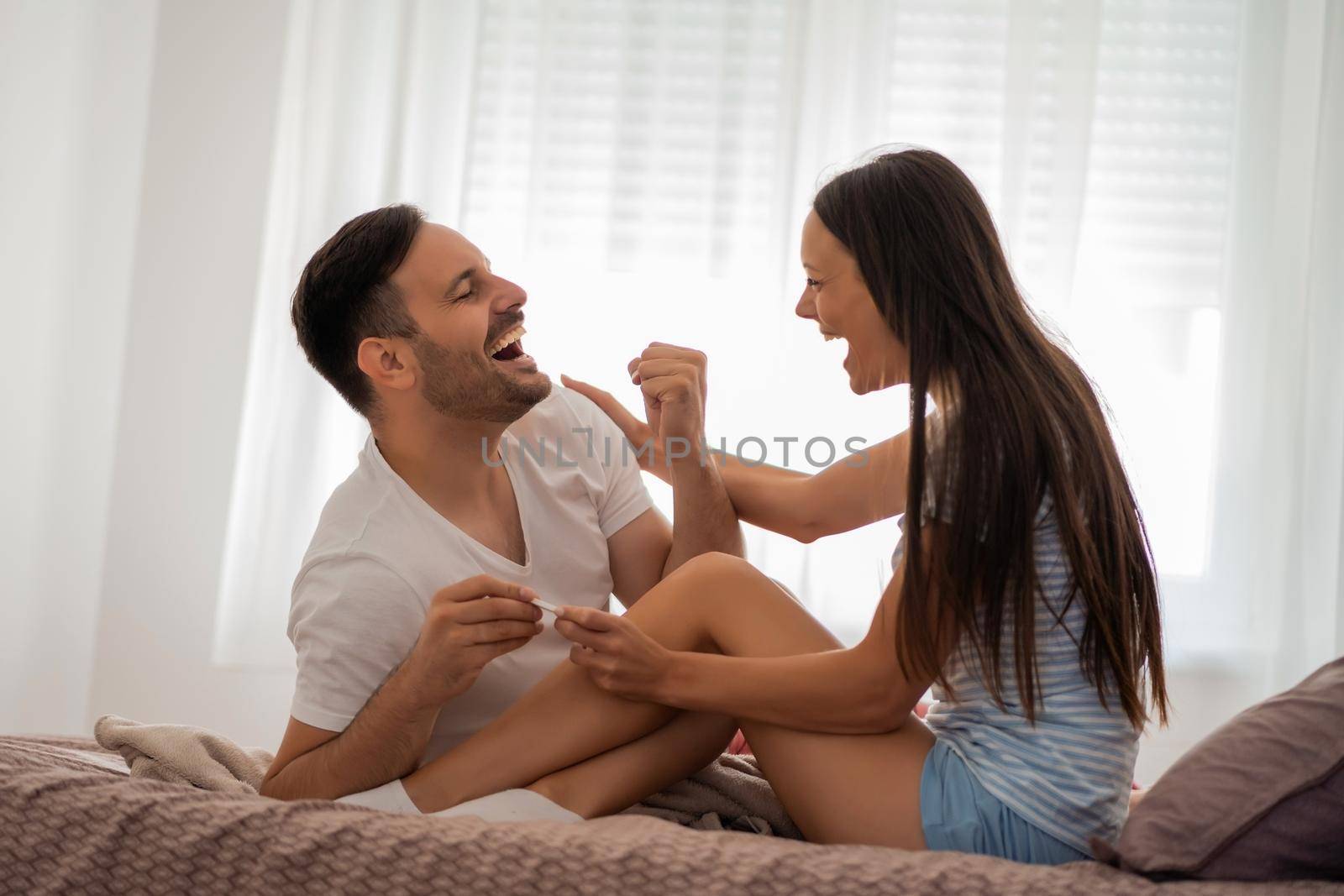 Young couple is happy because of positive pregnancy test.