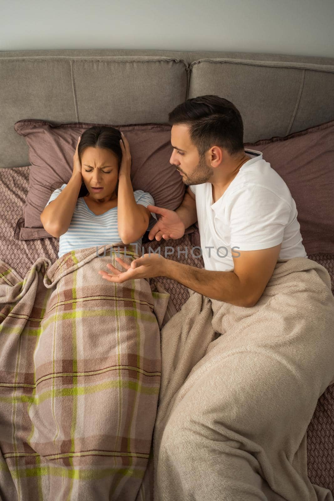 Young couple is arguing in bed.