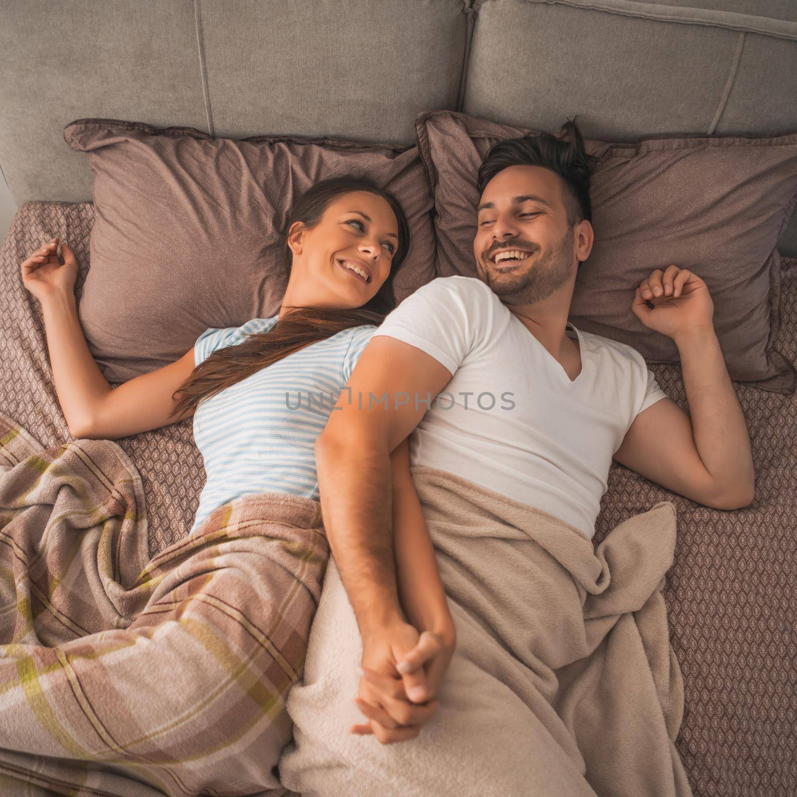 Young couple is resting in bed after work.