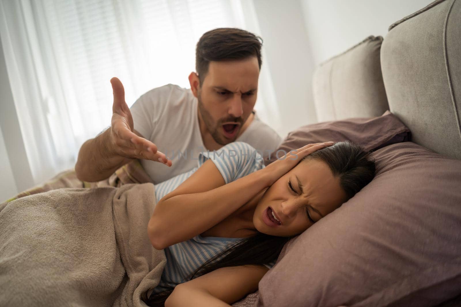 Young couple is arguing in bed in the morning.