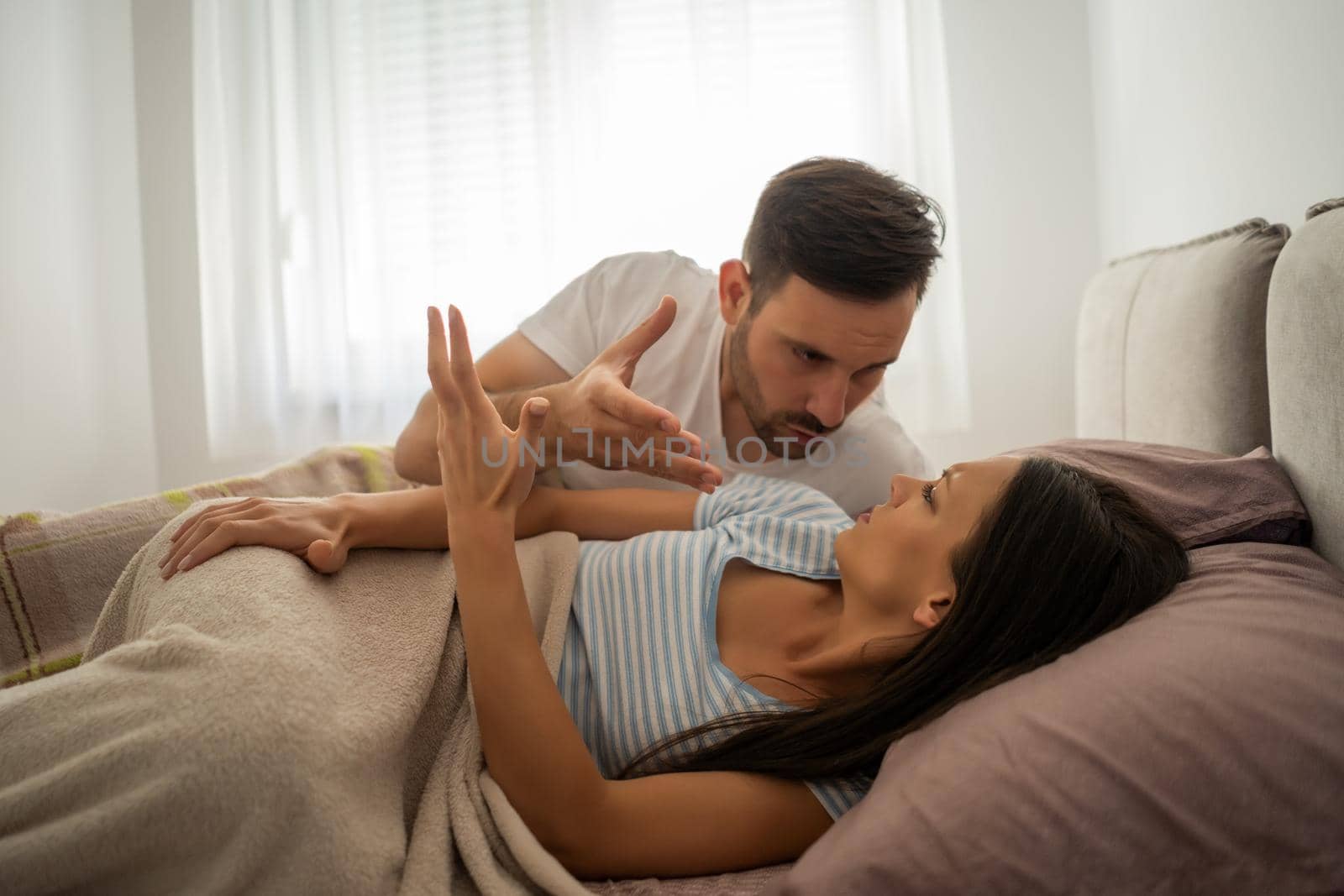 Young couple is arguing in bed in the morning.