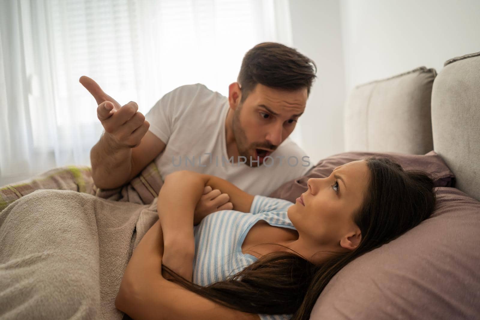 Young couple is arguing in bed in the morning.