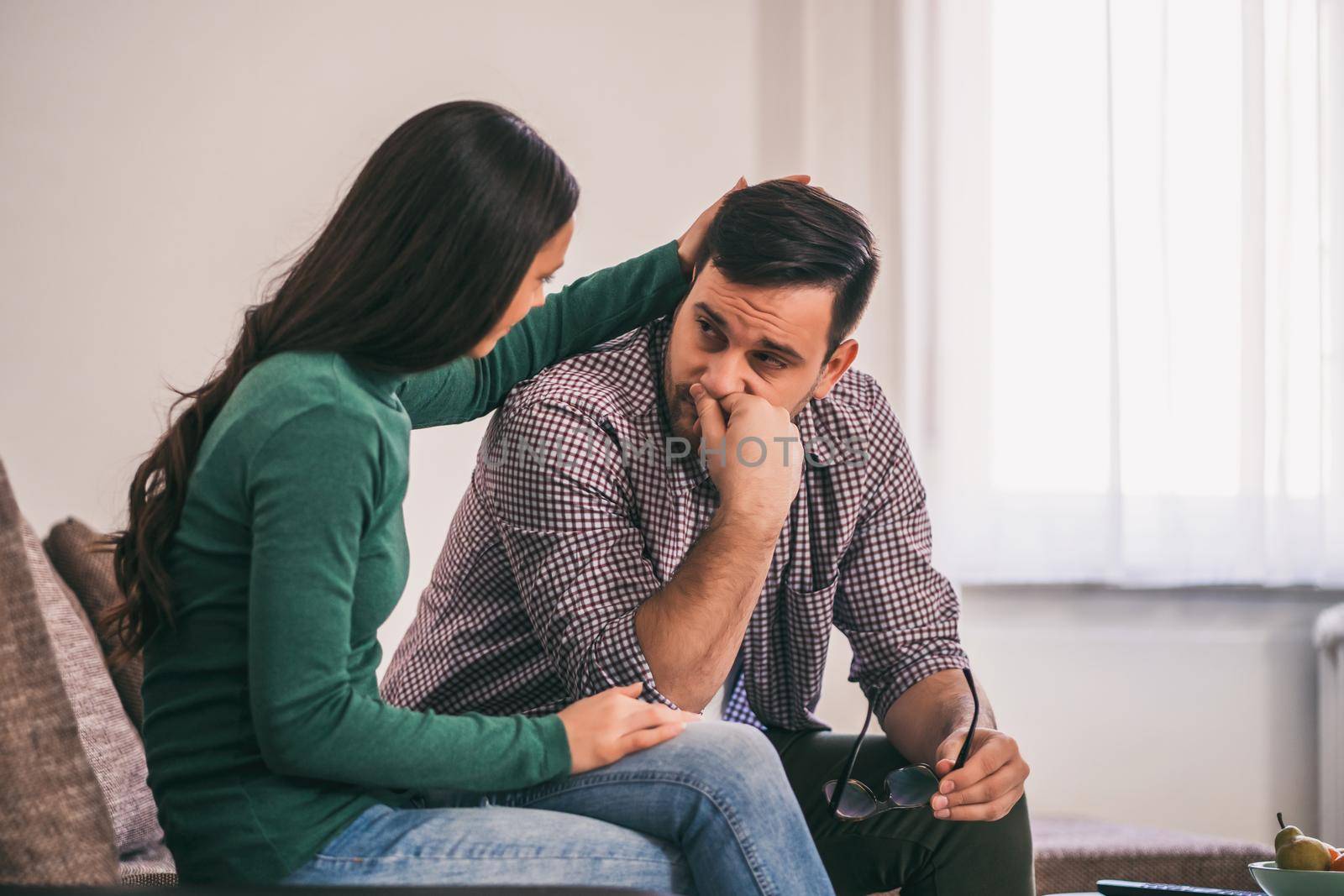 Man and woman are sitting at sofa and arguing. Relationship problems.