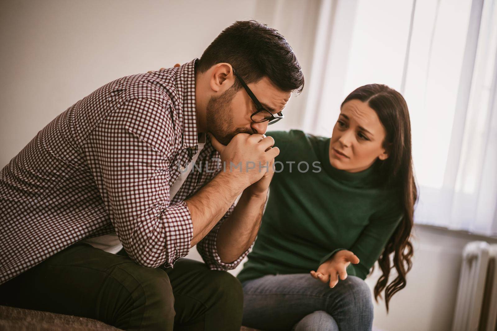 Man is sad and depressed, his wife is consoling him.