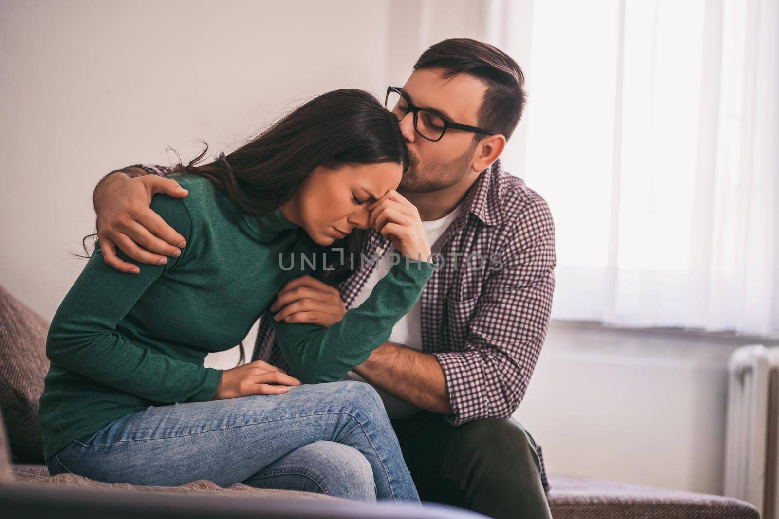 Woman is sad and depressed, her man is consoling her.