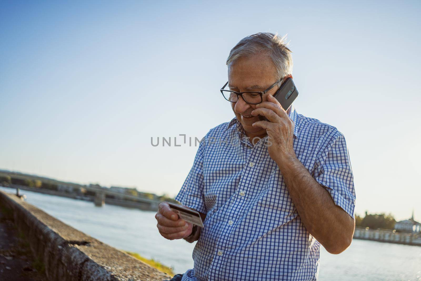 Outdoor portrait of senior man who is talking on phone.