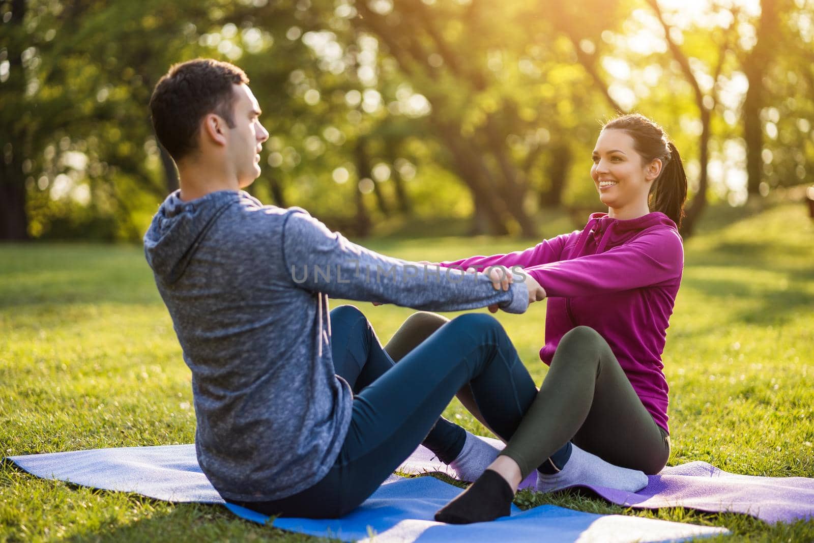 Couple is exercising in park. Exercise for sciatica recovery.