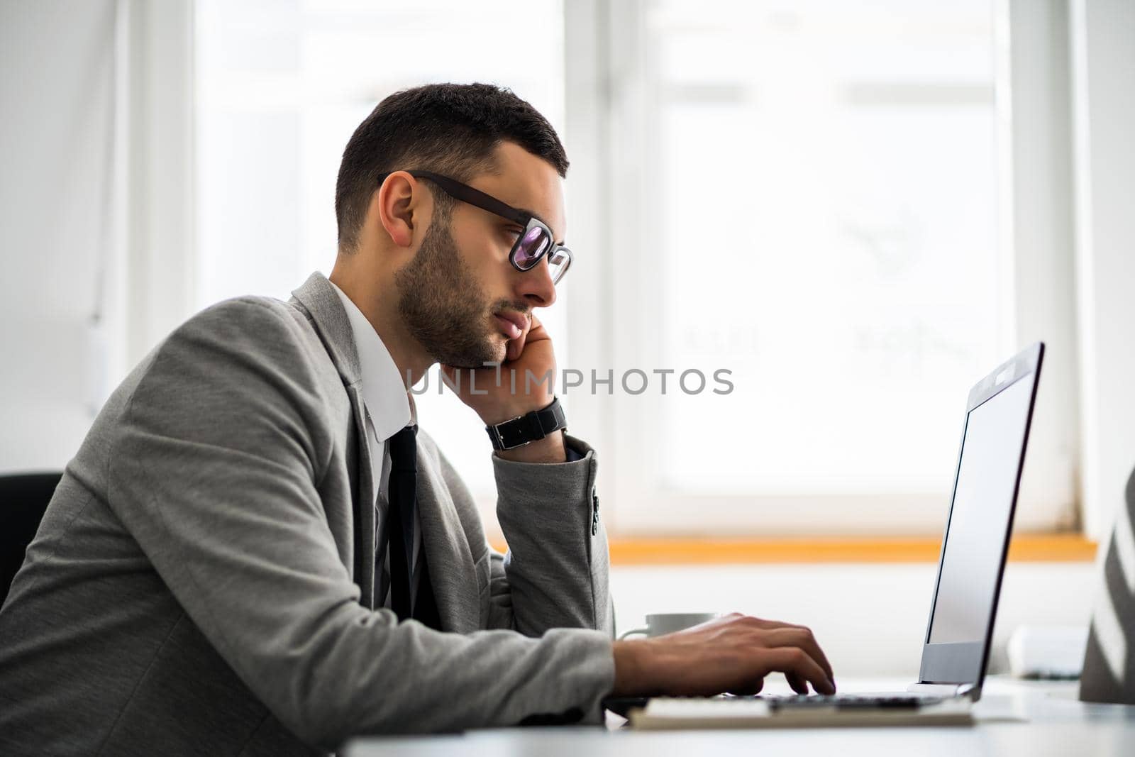 Young businessman is working in office. He is pensive and worried.