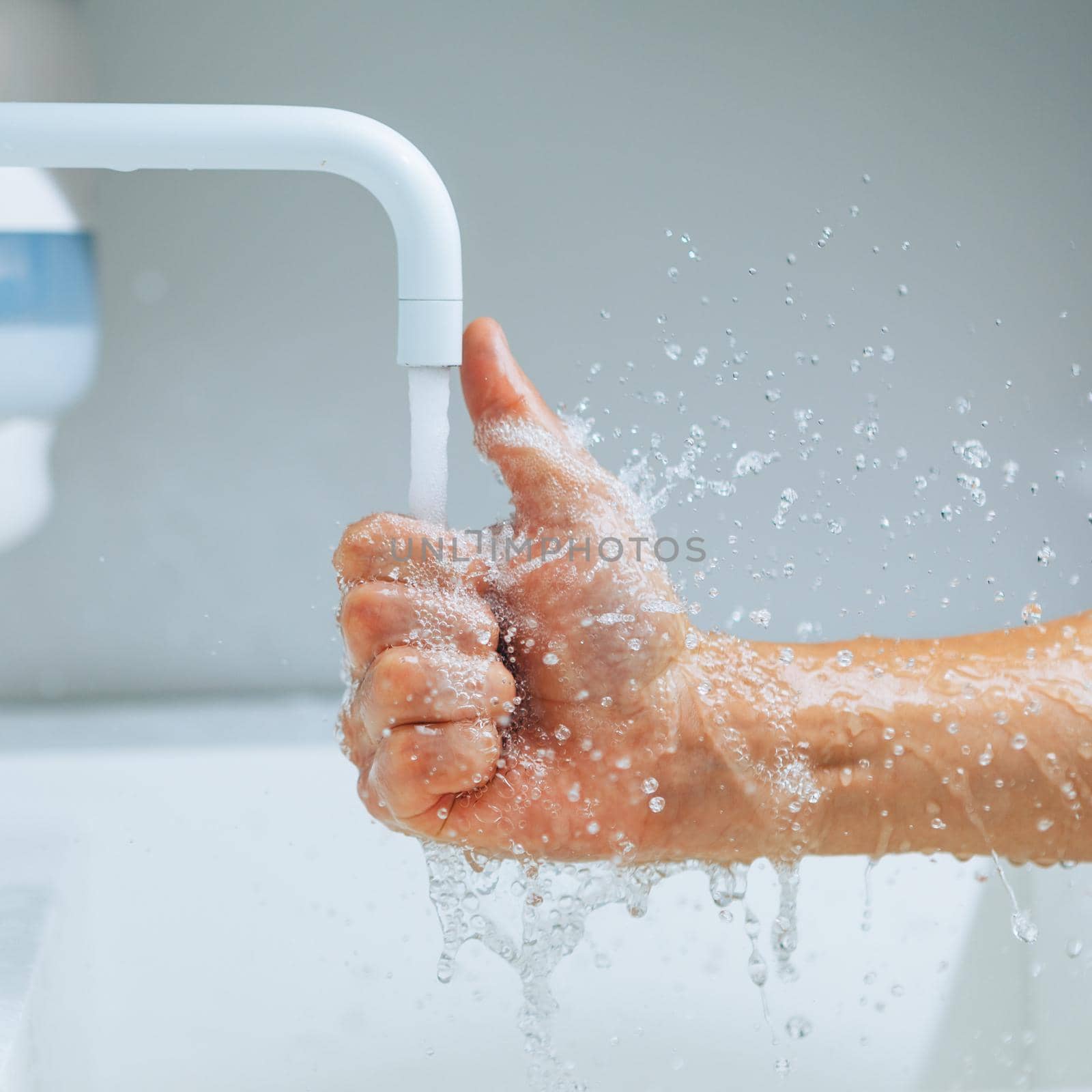 thumbs up hand under the mixer spout with flowing water