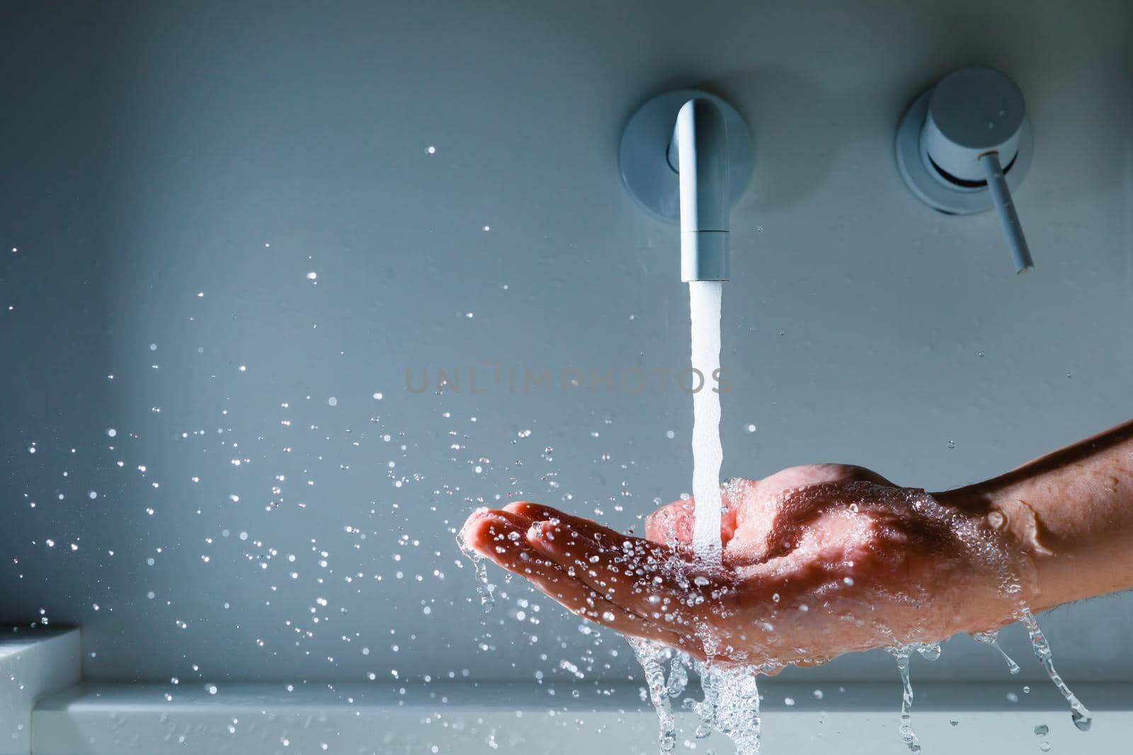 hand under the faucet with flowing water splash by nikkytok