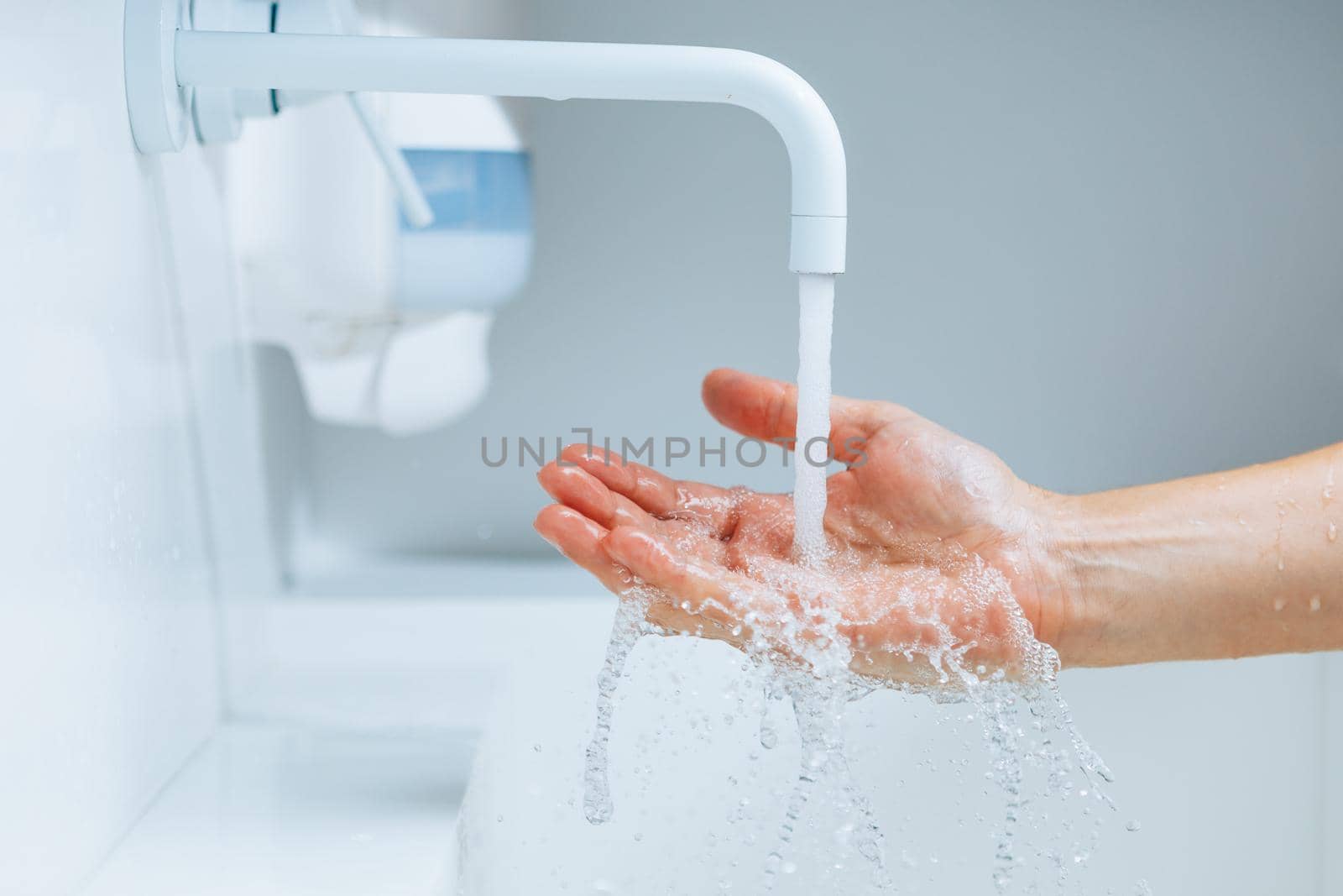 hand under the faucet with flowing water splash by nikkytok