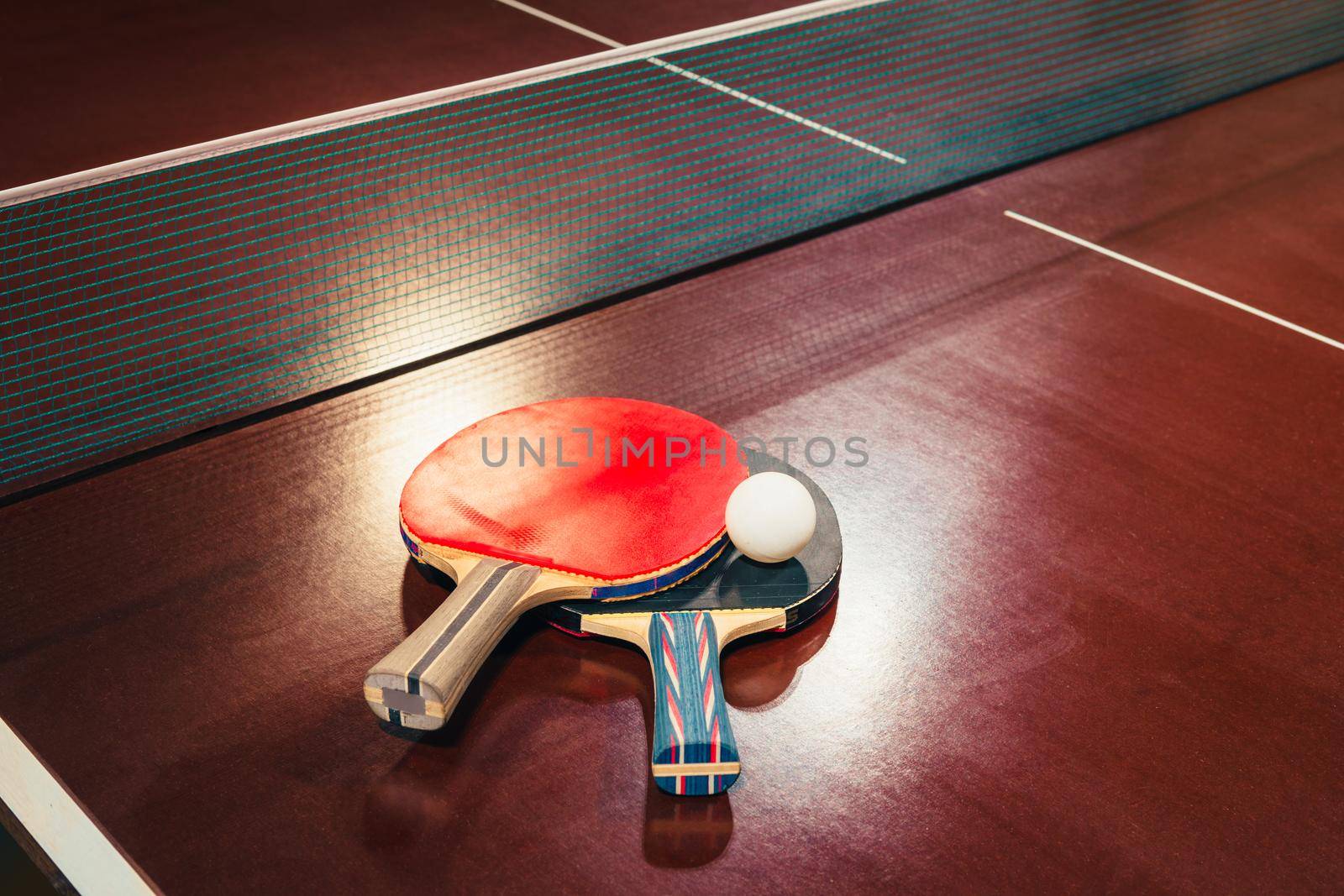 table tennis rackets and ball, net background