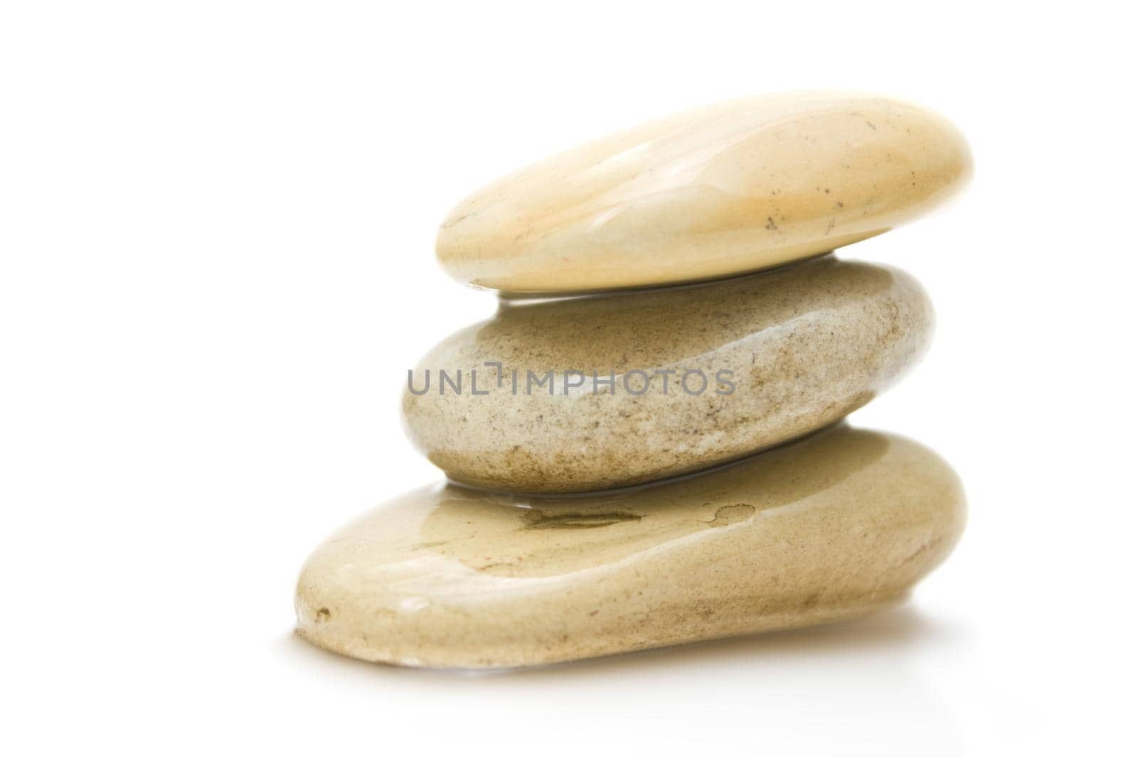 pile of hot massage stones - beauty, spa and body care styled concept by Anneleven