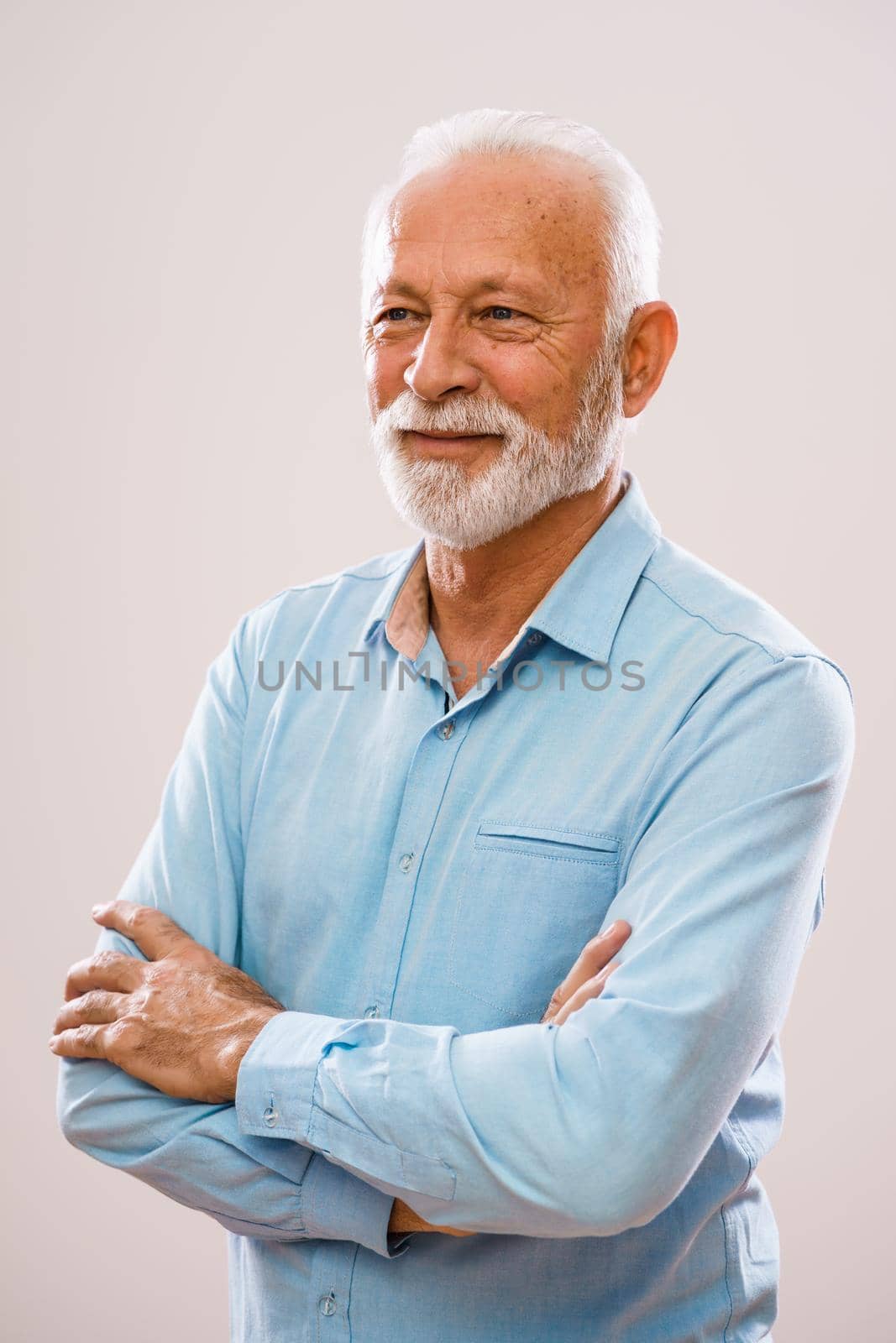 Portrait of cheerful senior man who is looking away and smiling.