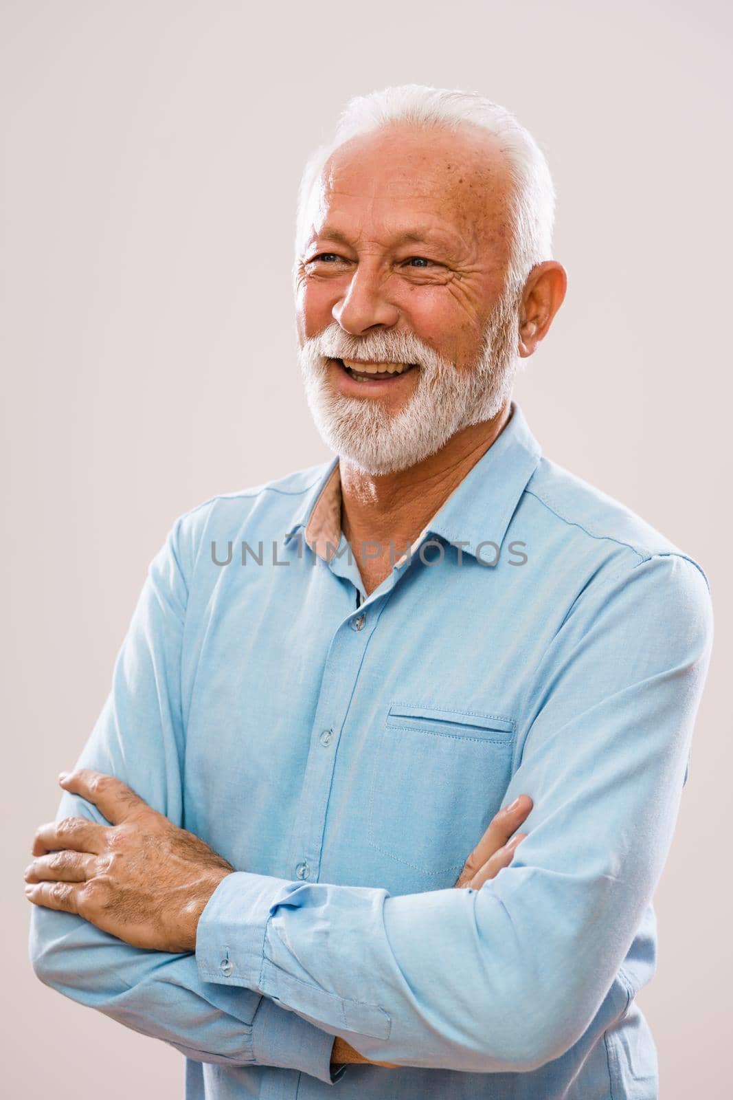 Portrait of cheerful senior man who is looking away and smiling.