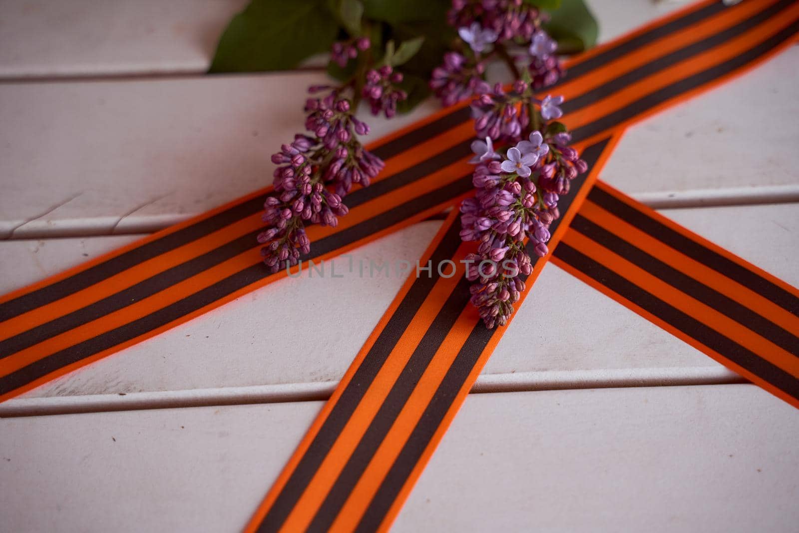 Spring flowers lilac branch with St. George ribbons. Victory Day Photos. High quality photo